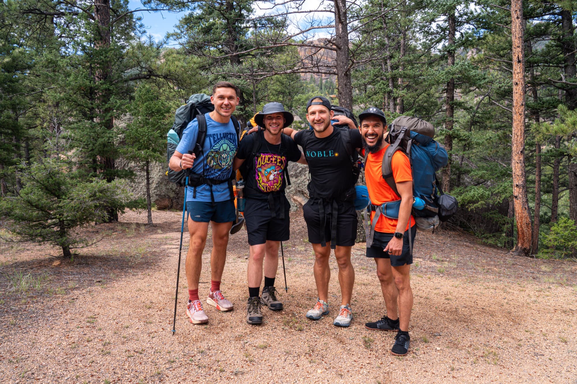 Elevate members with packs at the trailhead in the Colorado pines